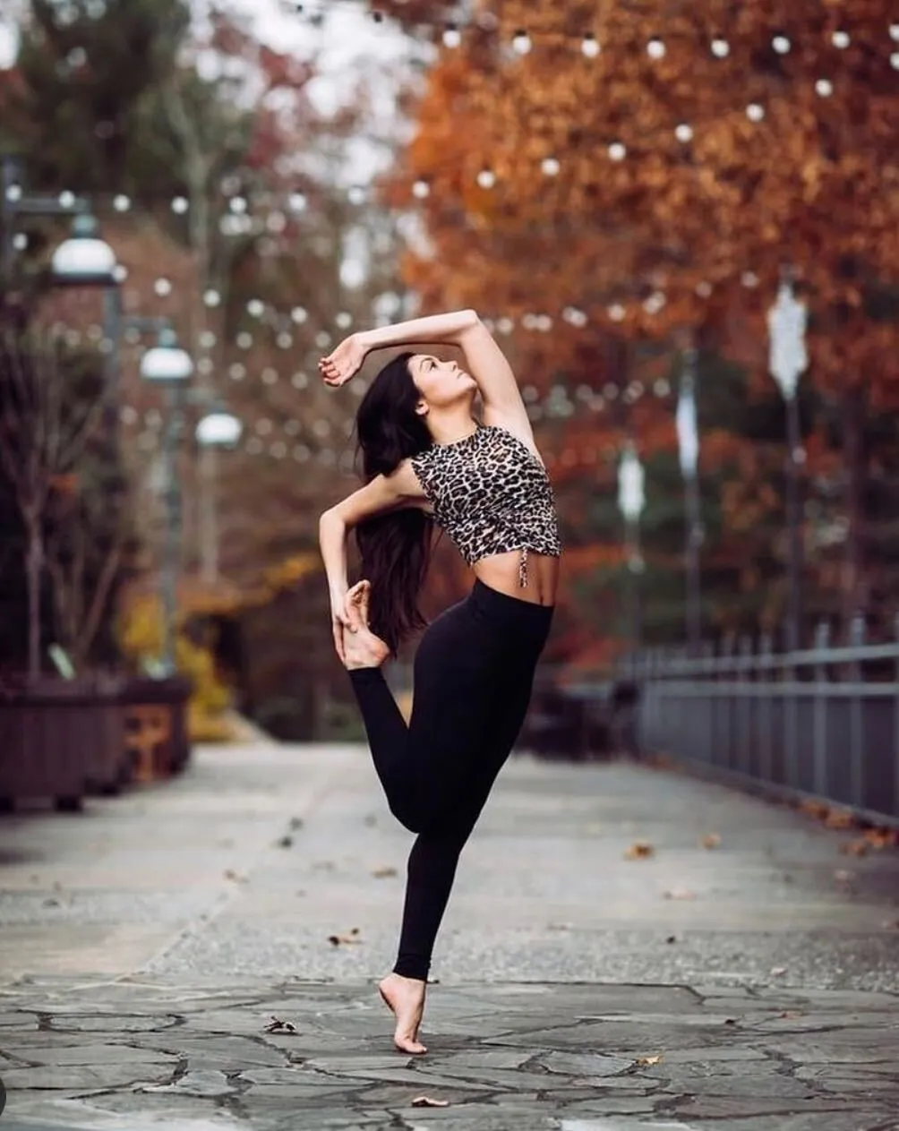 Woman doing a foot grab dance pose.